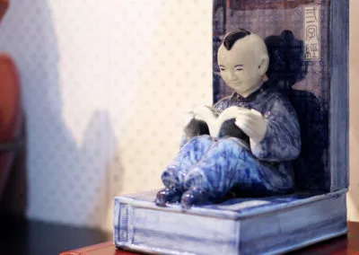 Table lamp design - Chinese boy sitting on a stack of books