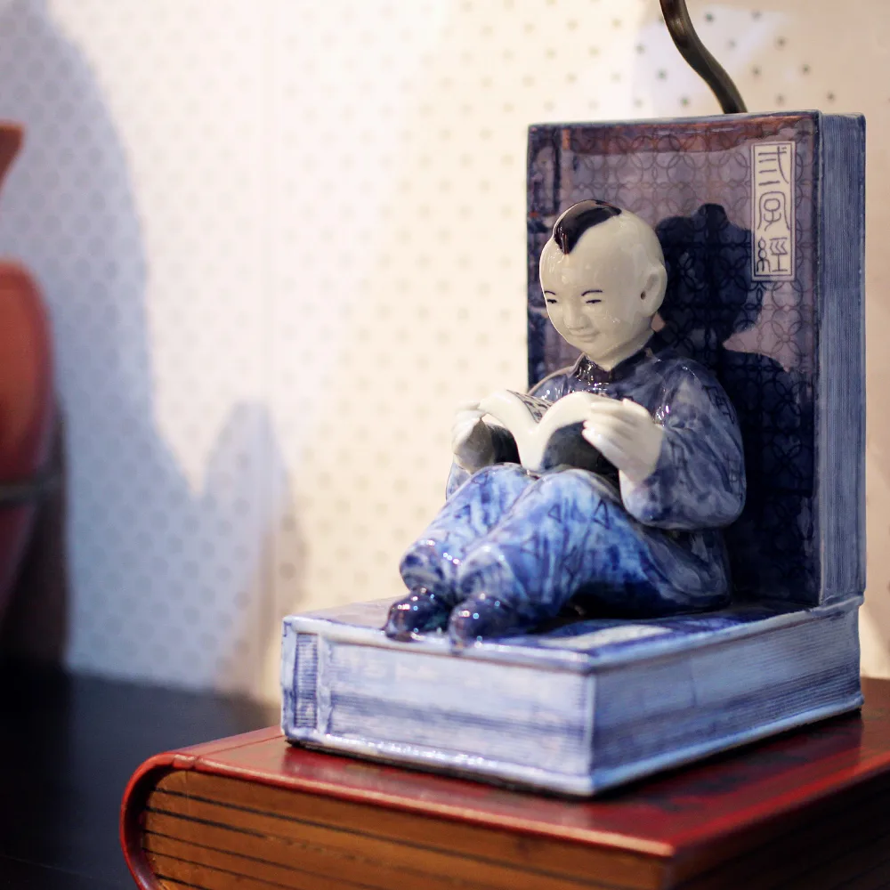 Table lamp design - Chinese boy sitting on a stack of books