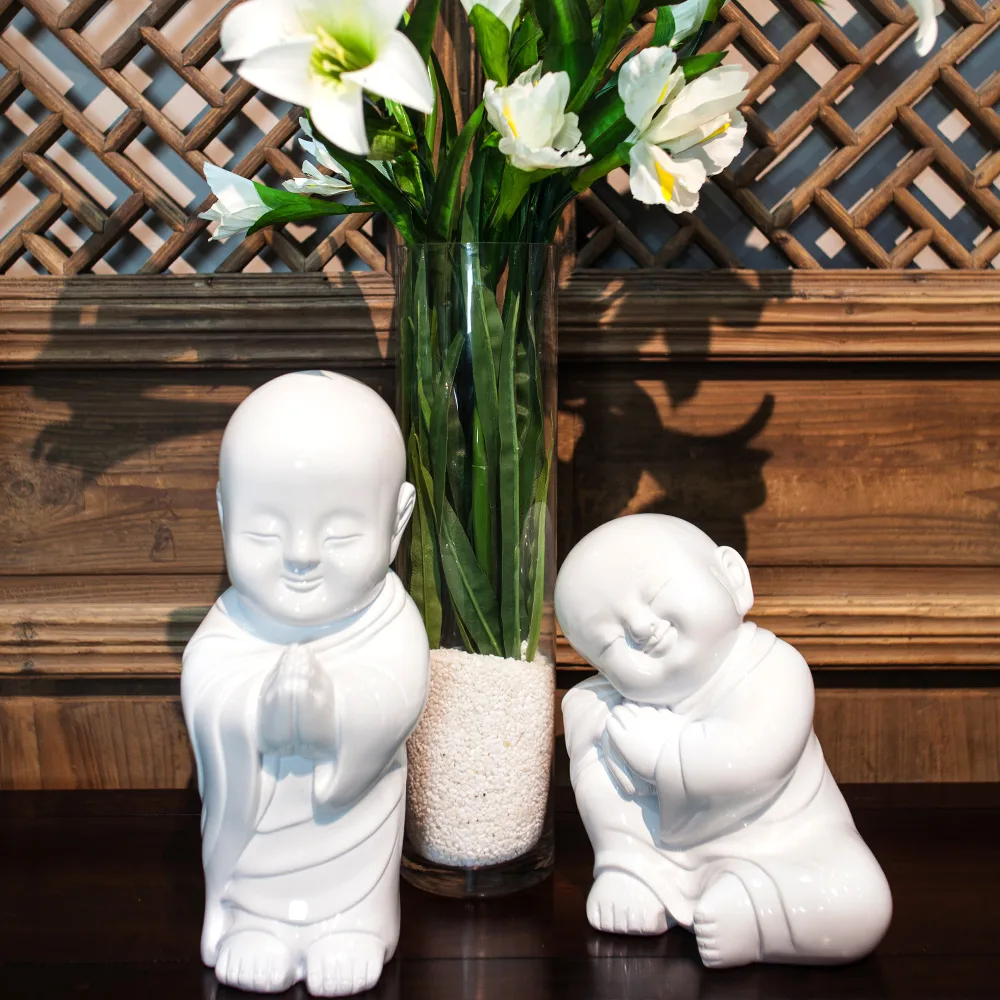 A pair of white porcelain smiley figurines