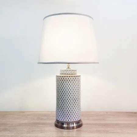 A tall round ceramic blue & white table lamp with a metallic base