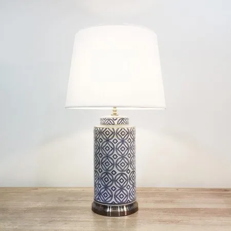 A tall cylindrical ceramic table lamp with repeated motifs of the chinese coin in blue & white