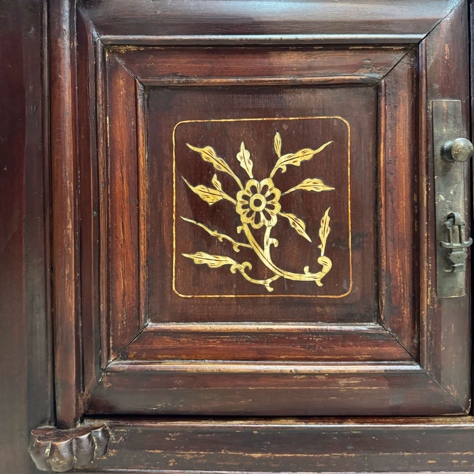 Close up on the bone inlaid designs on the doors of a chinese antique cabinet