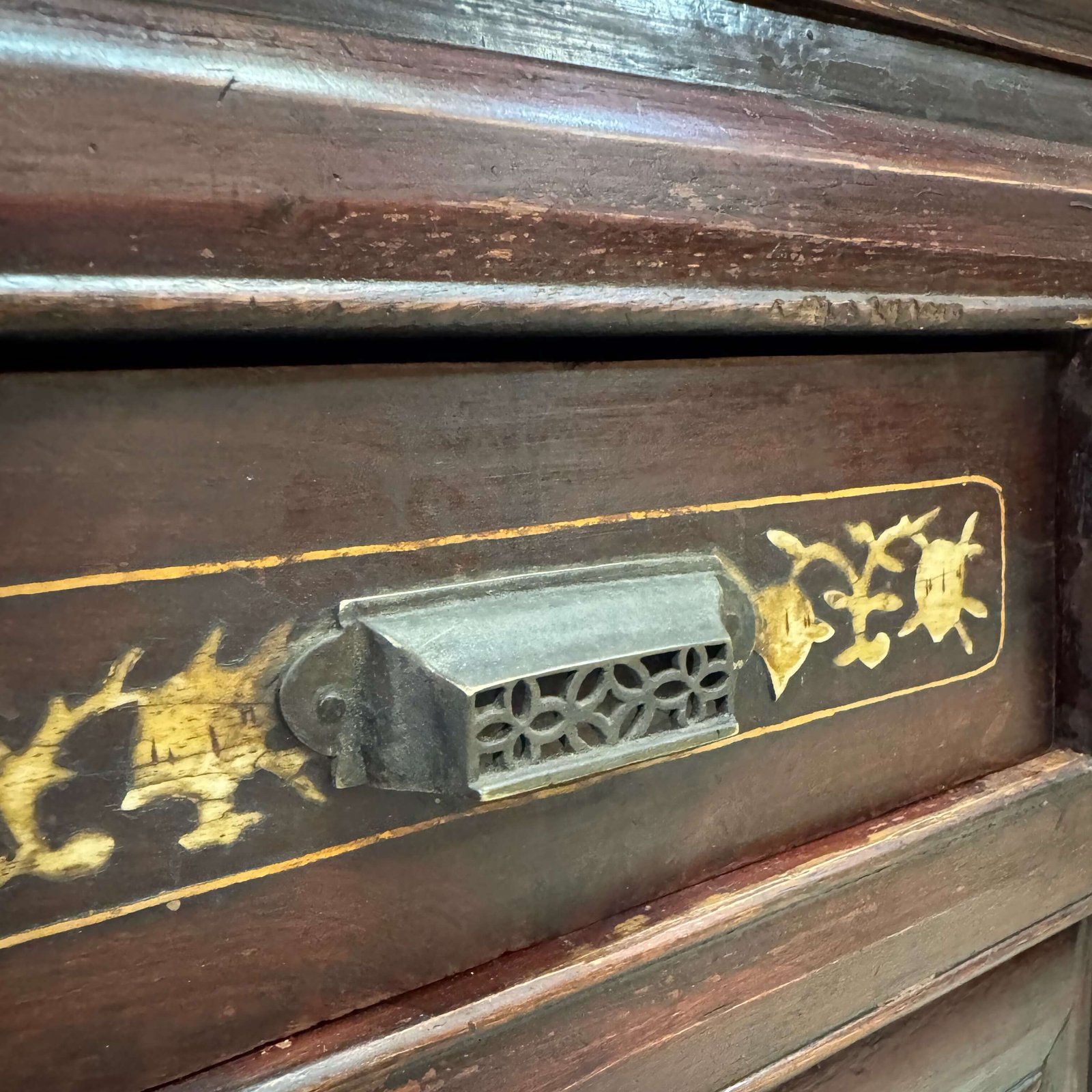 Close up on the brass handle on the drawer of a chinese antique cabinet