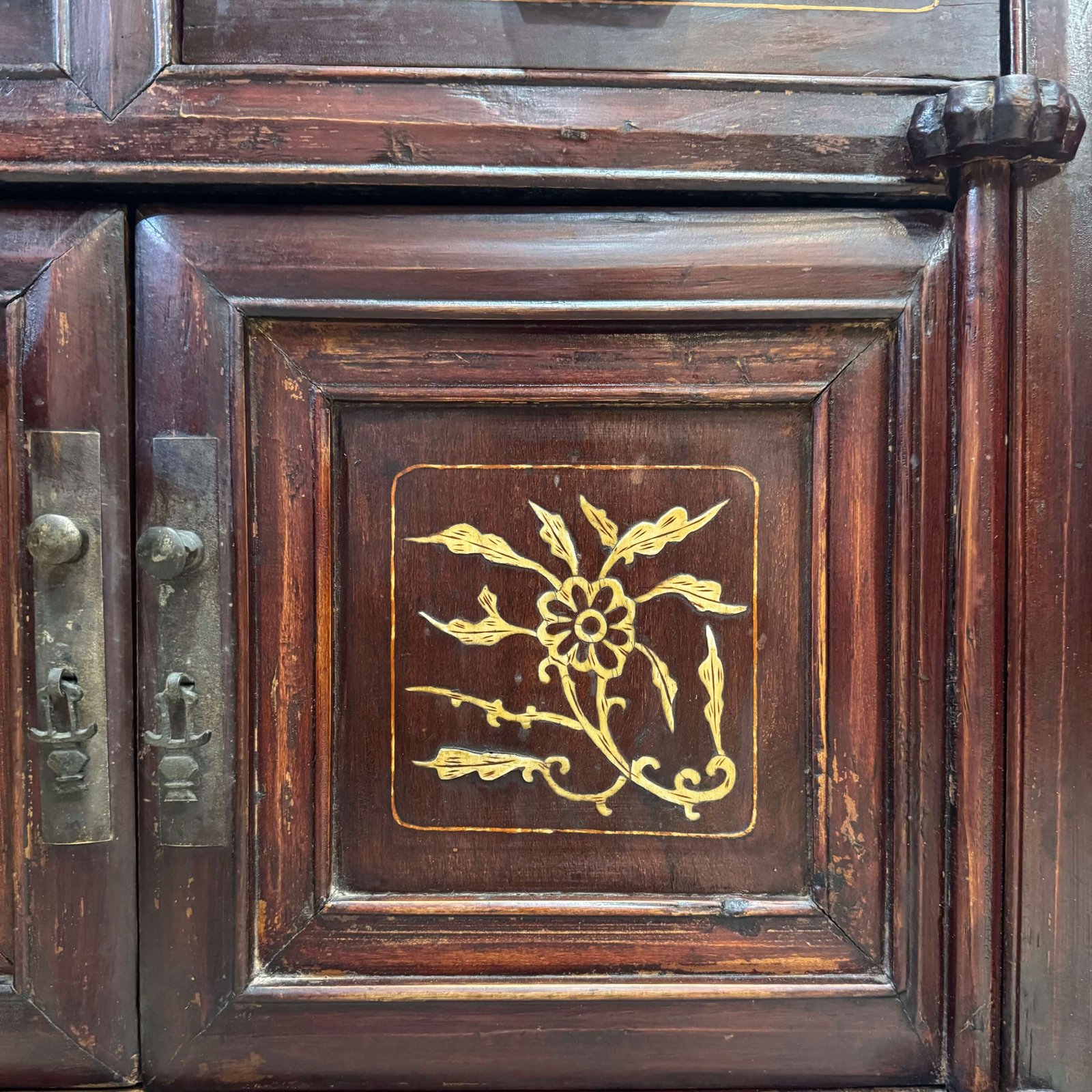 Close up on the bone inlaid designs on the doors of a chinese antique cabinet