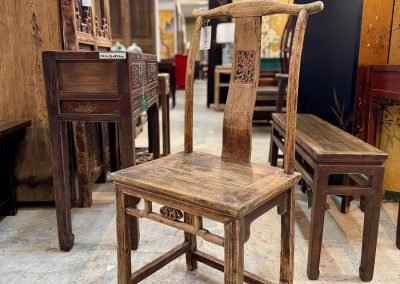 A small light brown vintage chinese chair with carving on the back splat