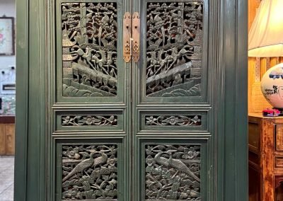 A tapered cabinet in sea green with vintage carved doors