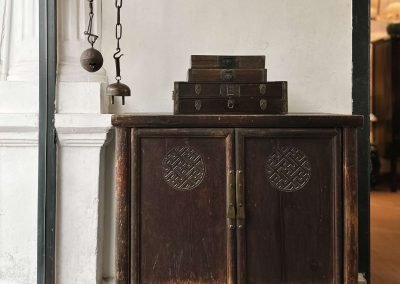 Chinese antique furniture, a Shandong cabinet with relief carvings on the doors, and small flat boxes on top