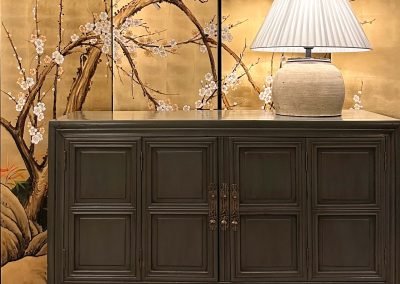 Chinese vintage medium cabinet with simple design, beautiful detailing along the door frames and door edges. The background is a set of gold leaf foldable screen with Chinese painting