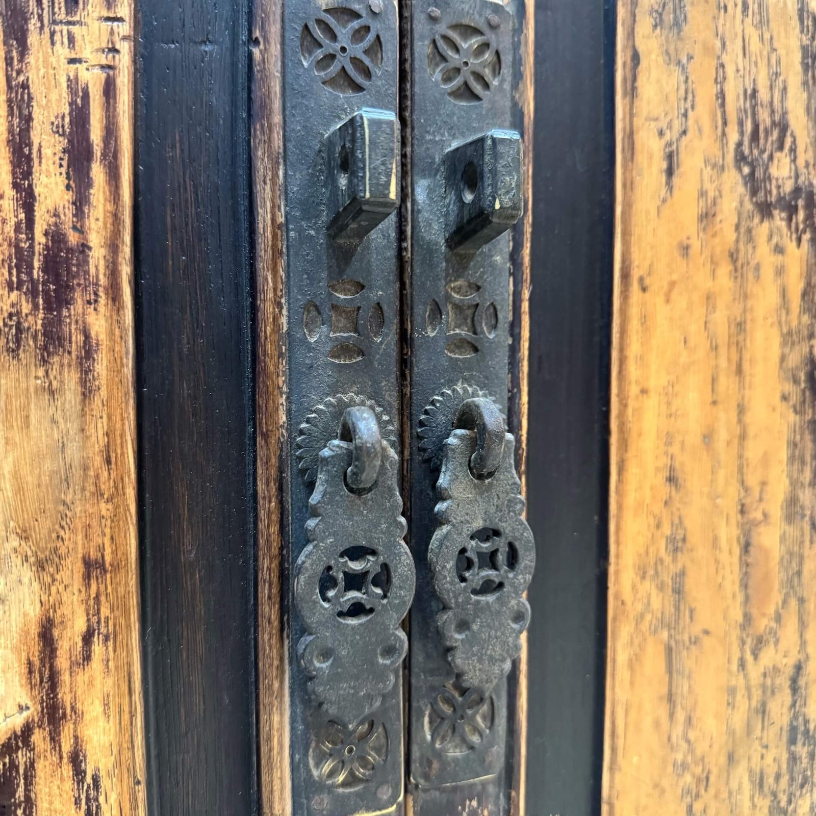 Close up of original chinese brass cabinet door handles with coin and floral motifs